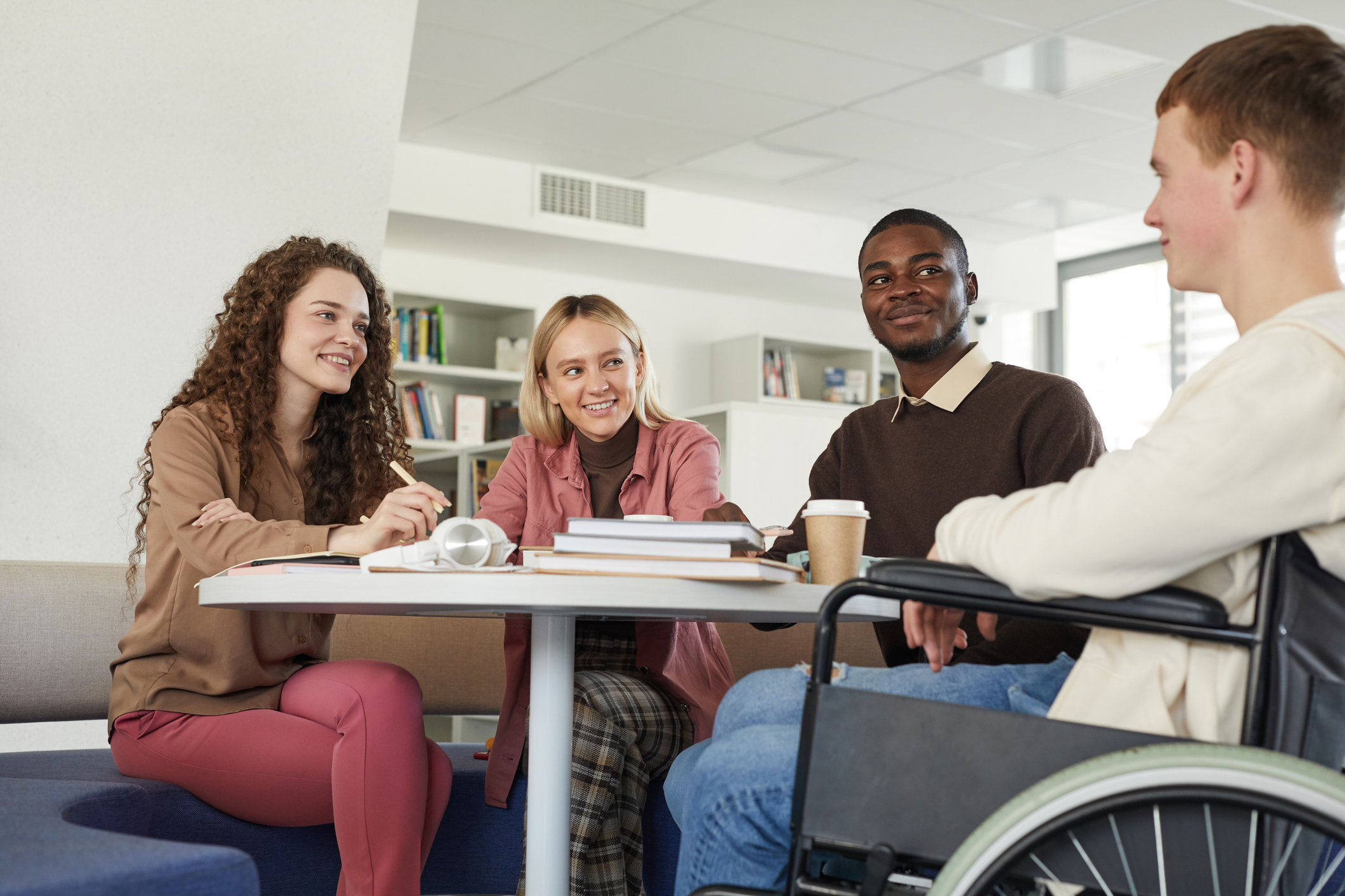 Four young adults having a conversation around a table.